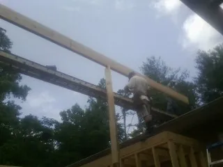 Carpenter setting a ridge beam over a new addition frame — Ice Dam Removal by Roofing Brothers in Truxton