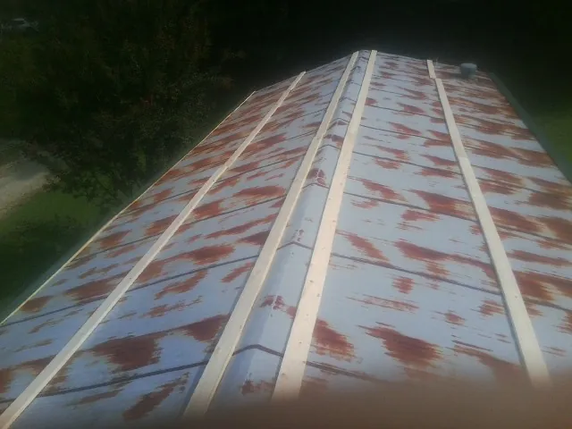 Rusted metal roof panels with new wood purlins before replacement — Storm Damage Roof Repair in Truxton by Roofing Brothers