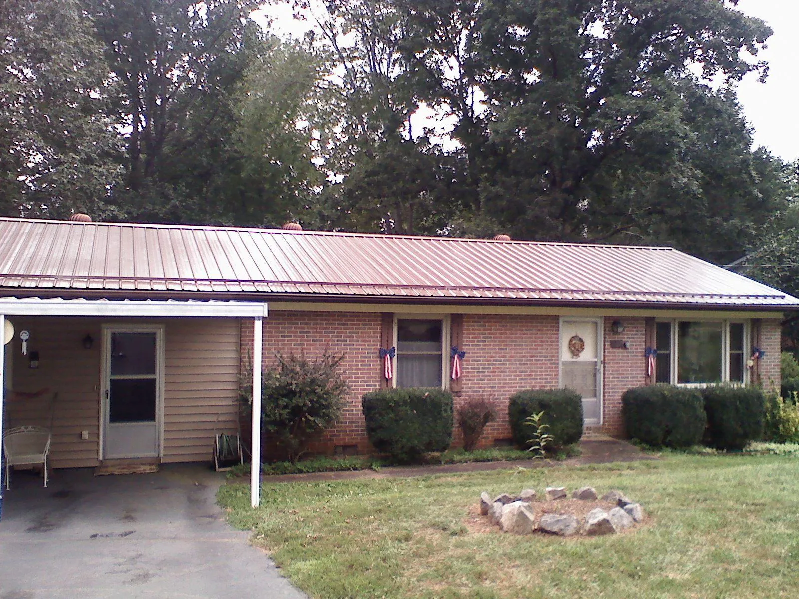 Bronze metal roof and carport on a brick ranch home — Roof Repair work by our crew in Truxton